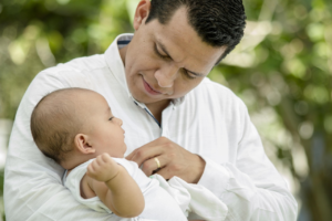 A parent holding a baby with calm presence, demonstrating emotional co-regulation and a sense of safety through connection.